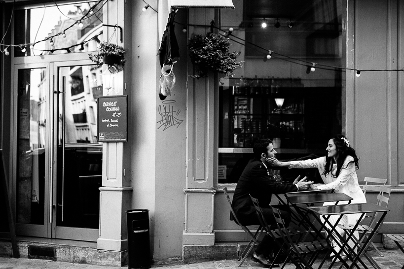 PHoto reportage de mariage en noir et blanc de mariés à la terrasse d'un café parisien